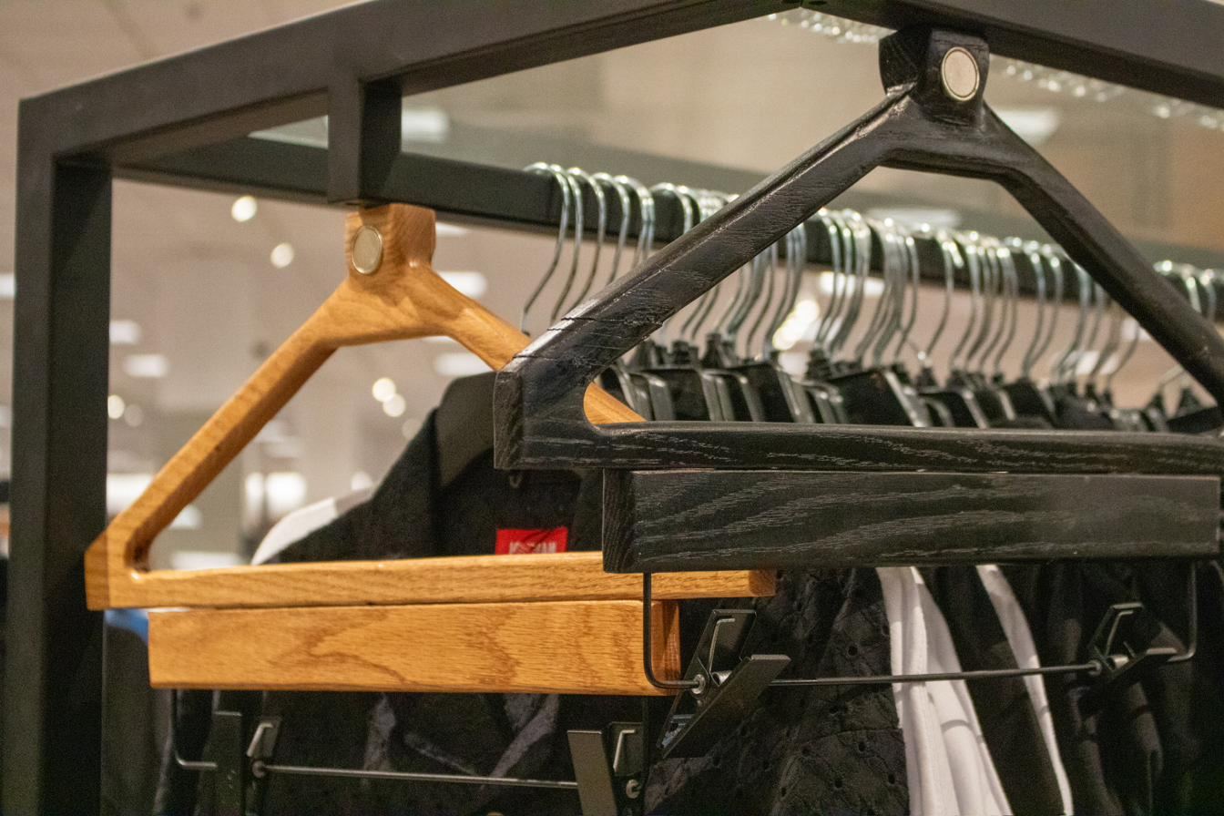 Attraxis wooden shirt hanger on a retail rack